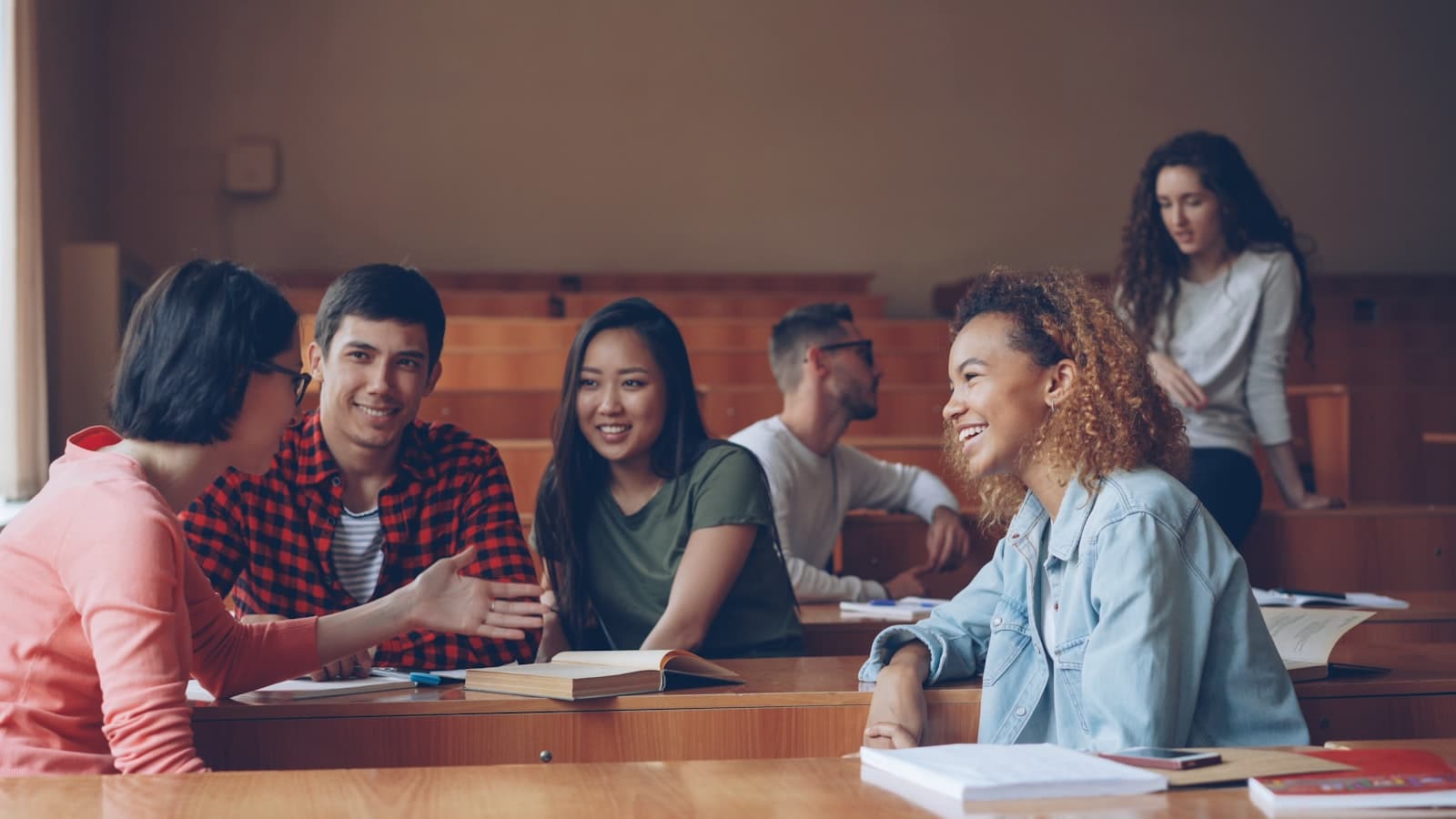 Students talking and laughing in a lecture hall — Photo by Vitaly Gariev on Unsplash