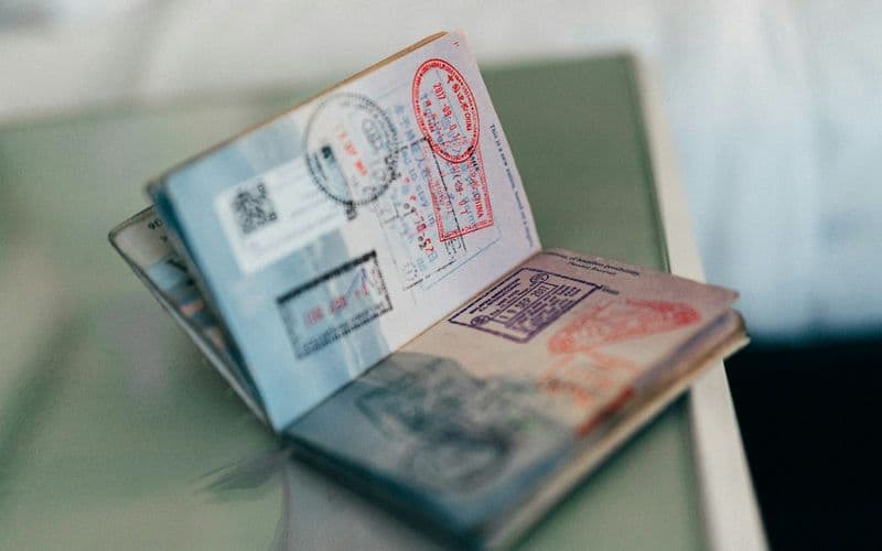 An open passport with multiple colorful ink stamps on the pages — Photo by Kit (formerly ConvertKit) on Unsplash