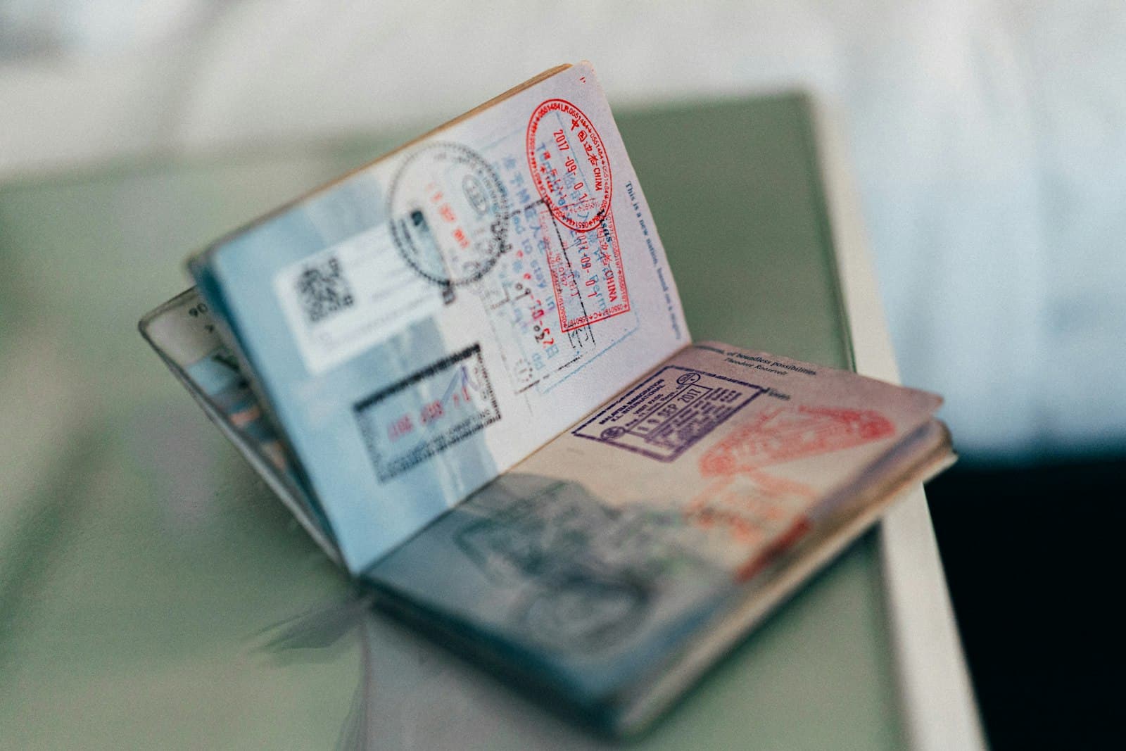 An open passport with multiple colorful ink stamps on the pages — Photo by Kit (formerly ConvertKit) on Unsplash